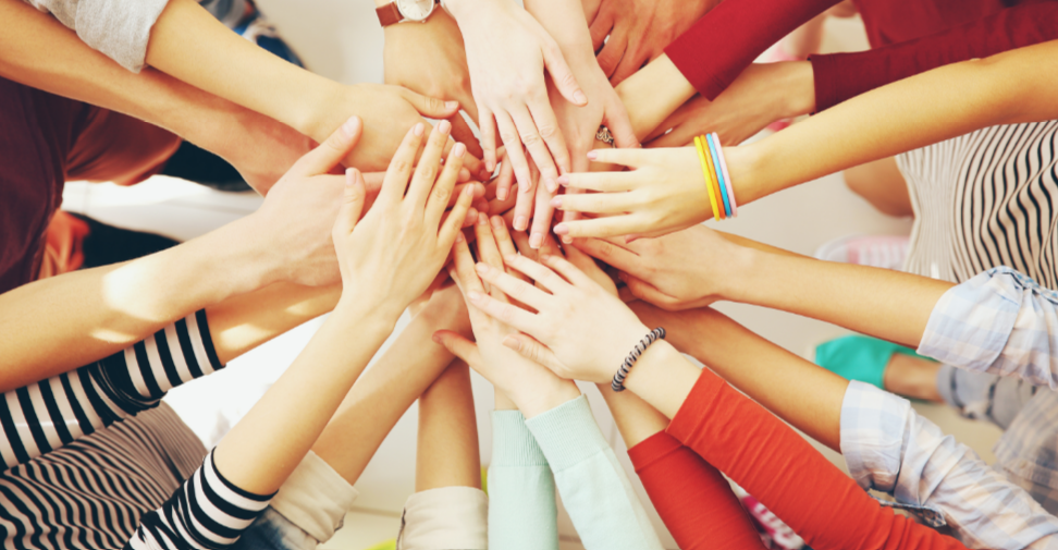 many hands in a high five pile 