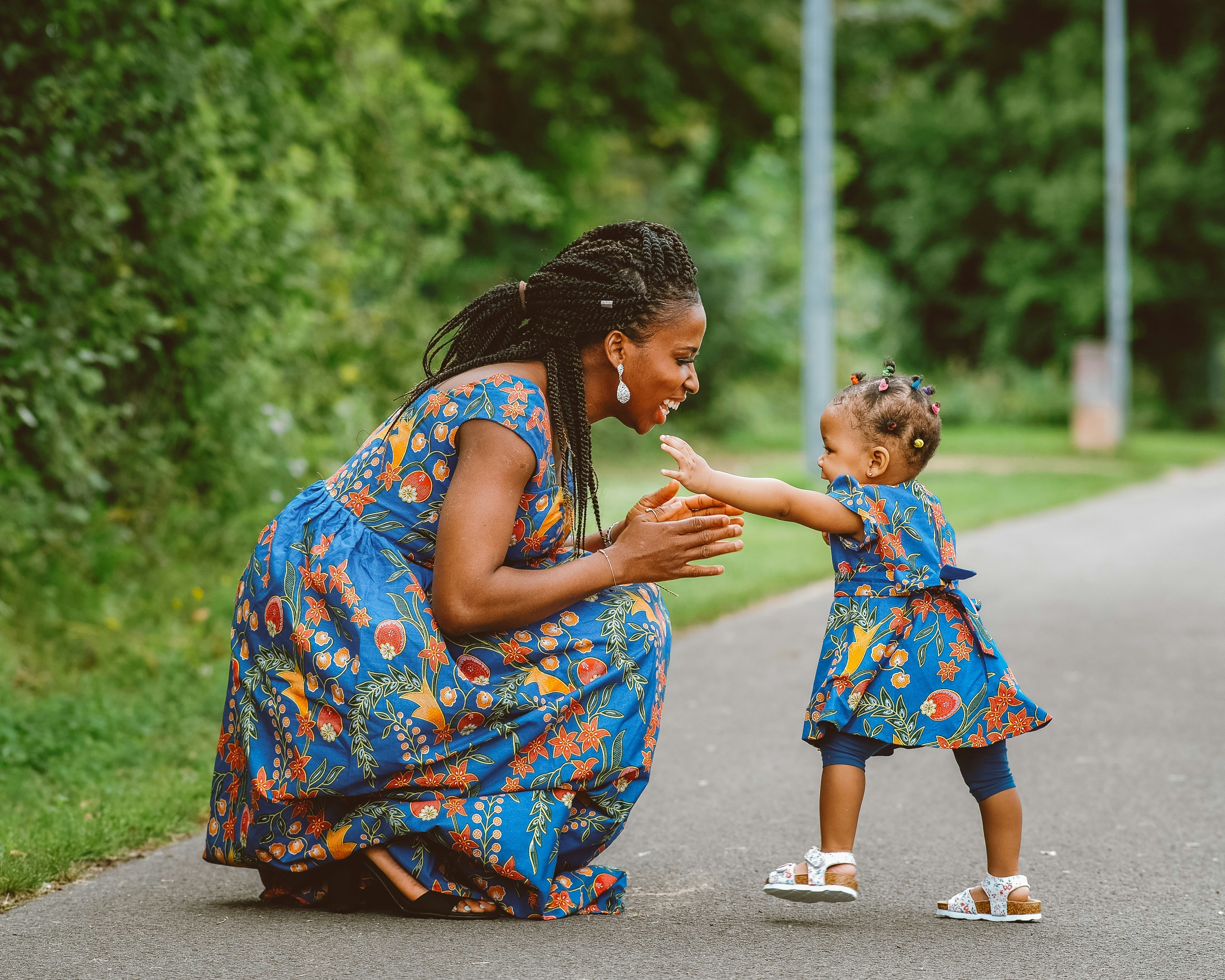 A mother kneeling down to play with her child