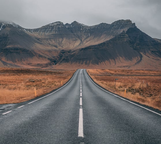 a road in the desert extending into the mountains in the distant