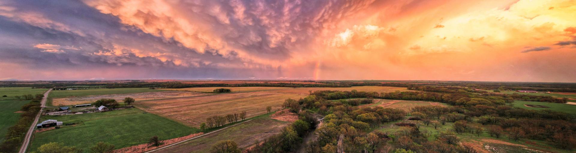evening view of the country side with rolling clouds of purple to yellow colors